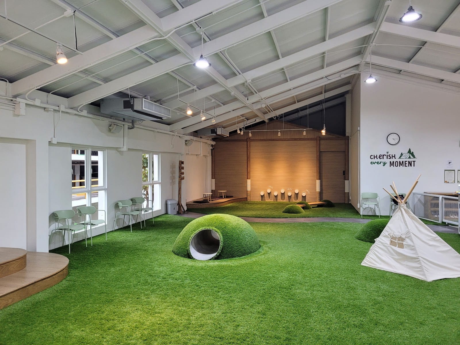 The indoor play hall with soft turf and a play tunnel